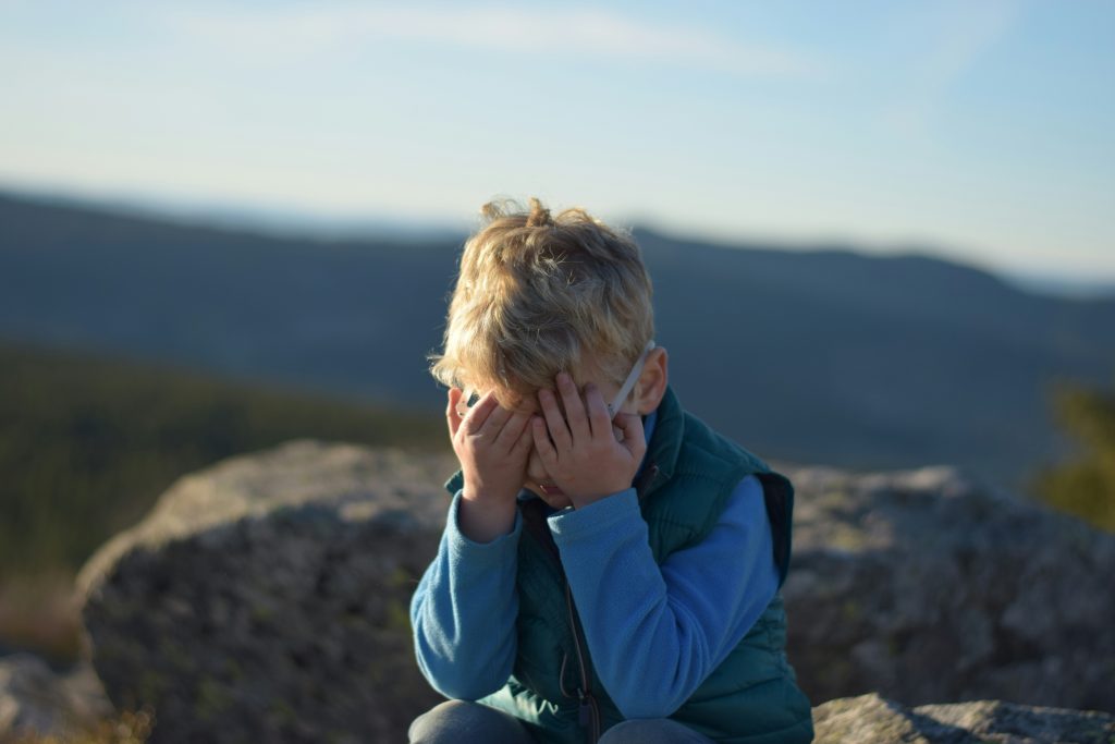 Boy covering face with shame
