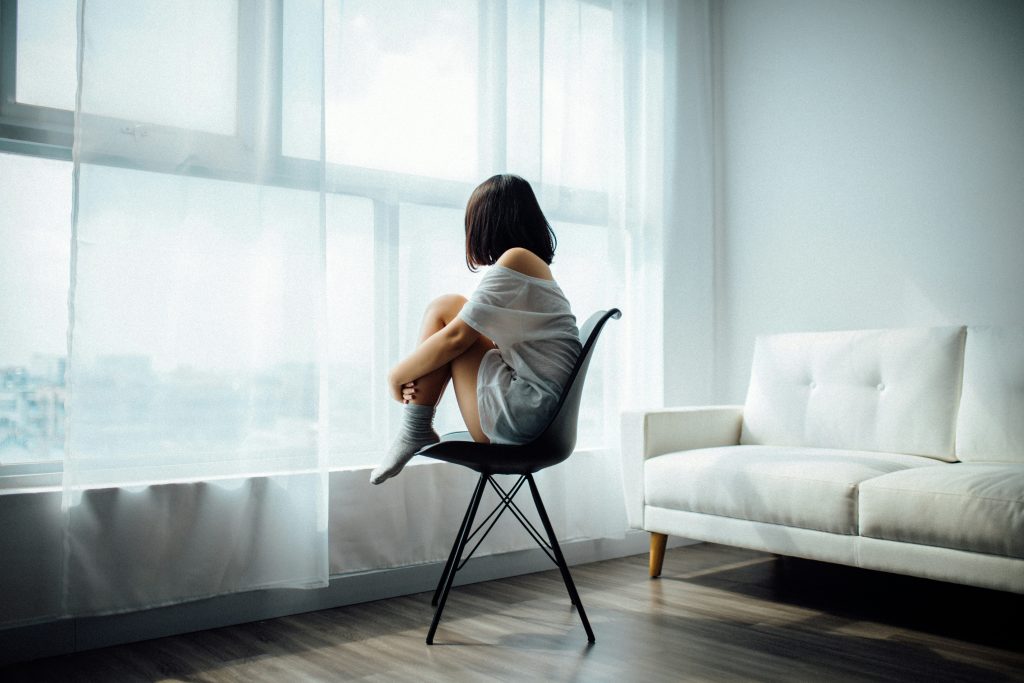 Depression counselling in Burnaby. Girl looking out her window.